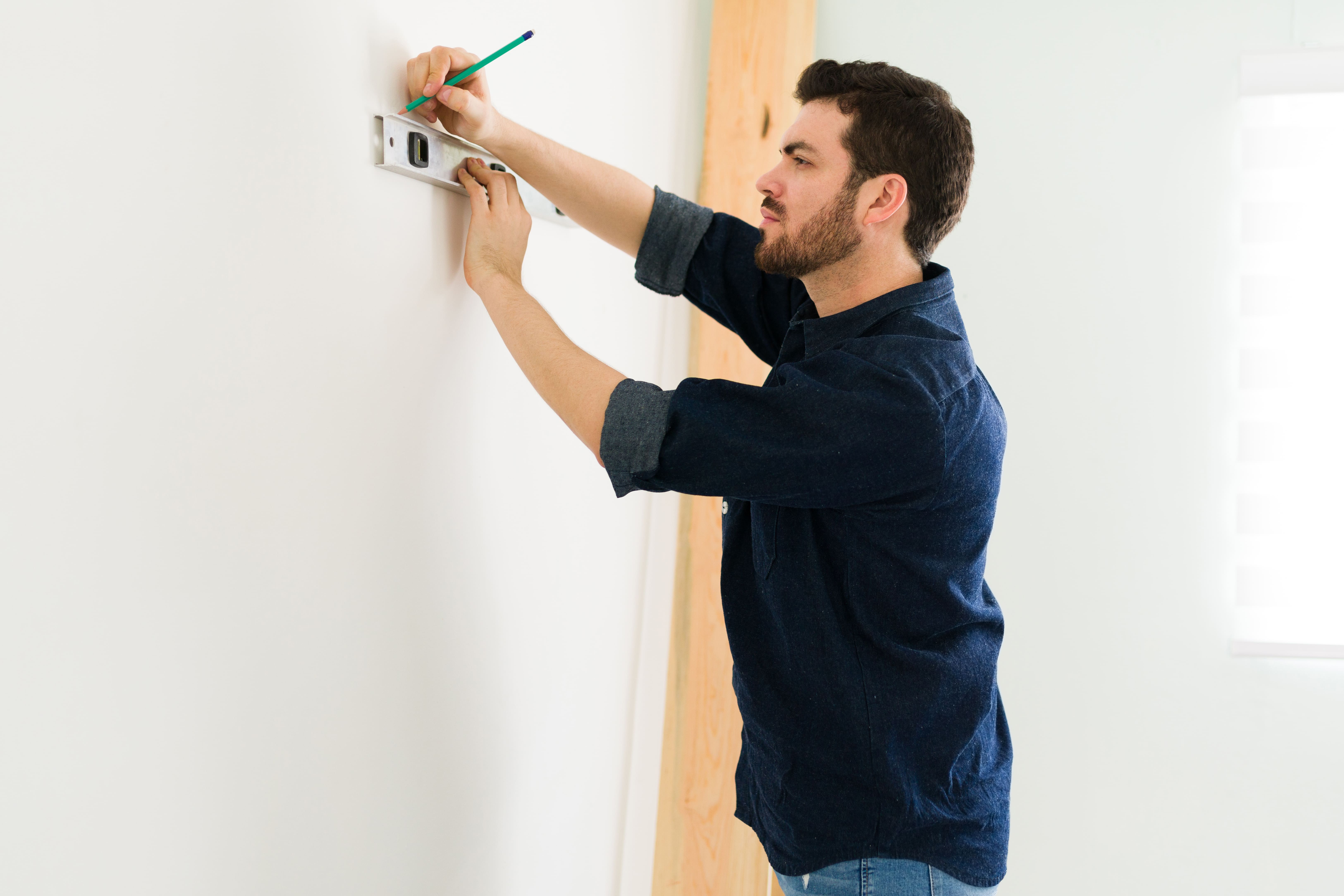 Handyman measuring wall